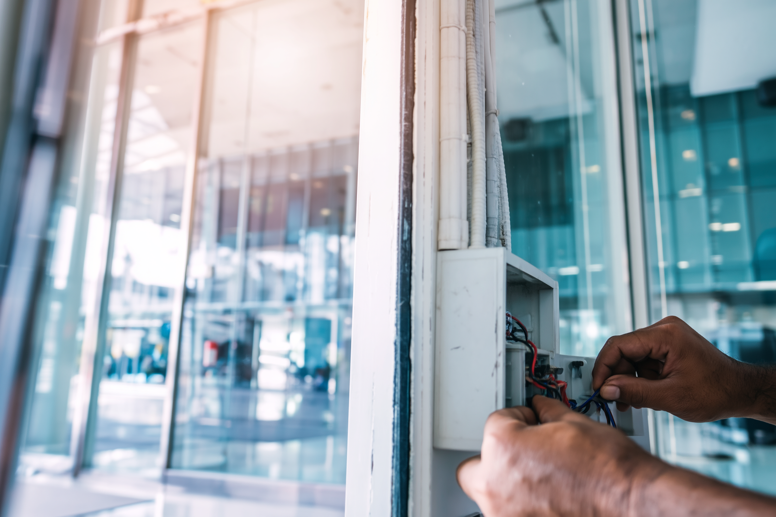 Security engineer installing access control panel on commercial premises